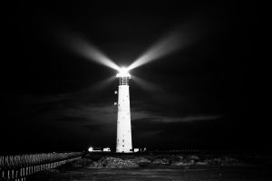 picture of lighthouse beaming into the night sky